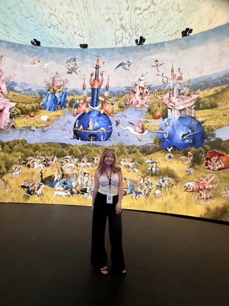 Kimberly in front of a projected Bosch painting
